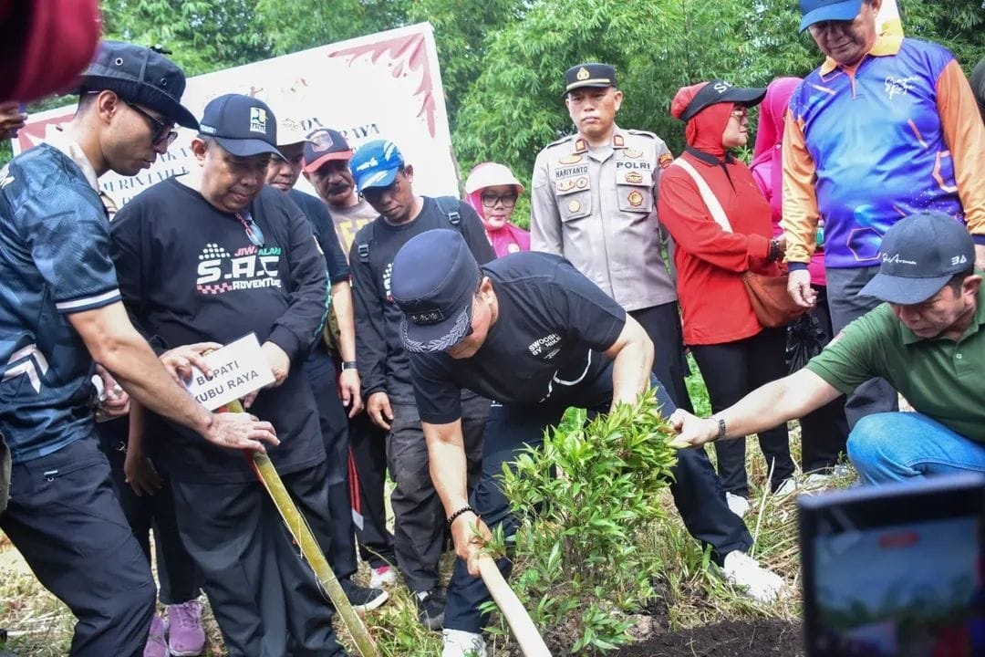 TANAM POHON: Bupati Kubu Raya, Sujiwo, menanam pohon di Jalan Sungai Raya Dalam sebagai gerakan pelestarian lingkungan, Jumat (31/10).