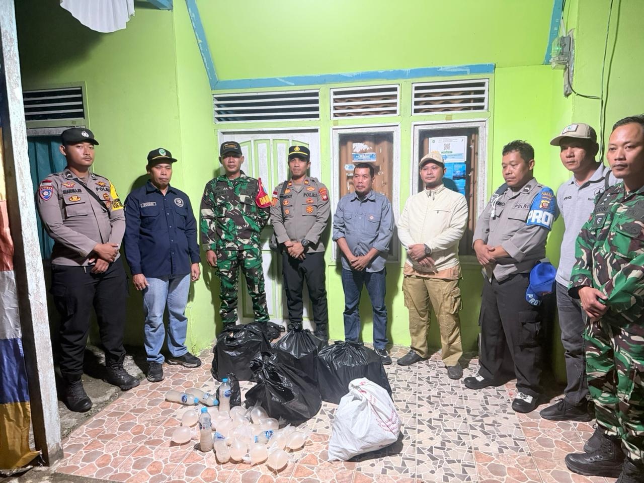 MIRAS: Petugas gabungan menyita puluhan liter minuman keras ilegal saat operasi penertiban di arena hiburan Desa Riam Panjang, Kecamatan Pengkadan, Jumat malam (31/10).