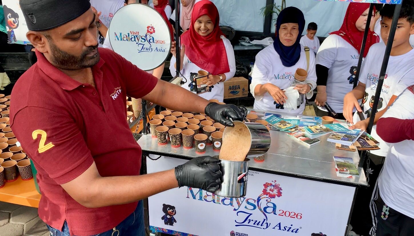 TEH TARIK: Warga antusias menikmati teh tarik gratis yang dibagikan Konsulat Malaysia di Pontianak saat Car Free Day di depan Ayani Megamal, Minggu (2/11) pagi.