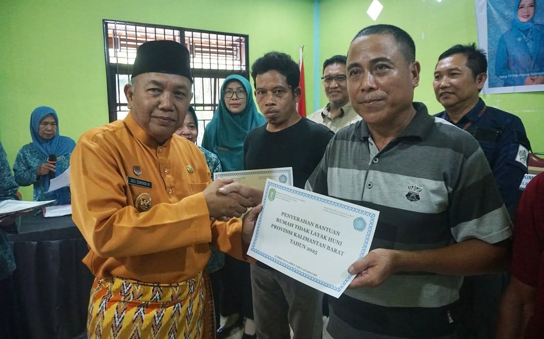 SERAHKAN: Wabup Juli menyerahkan bantuan RTLH kepada warga di Desa Pak Laheng.