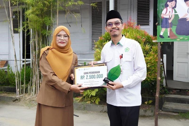 PENGHARGAAN: Kepala DLH Kota Singkawang Emy Hastuti menyerahkan penghargaan Sekolah Adiwiyata 2025 kepada perwakilan sekolah penerima di Singkawang, Selasa (4/11).