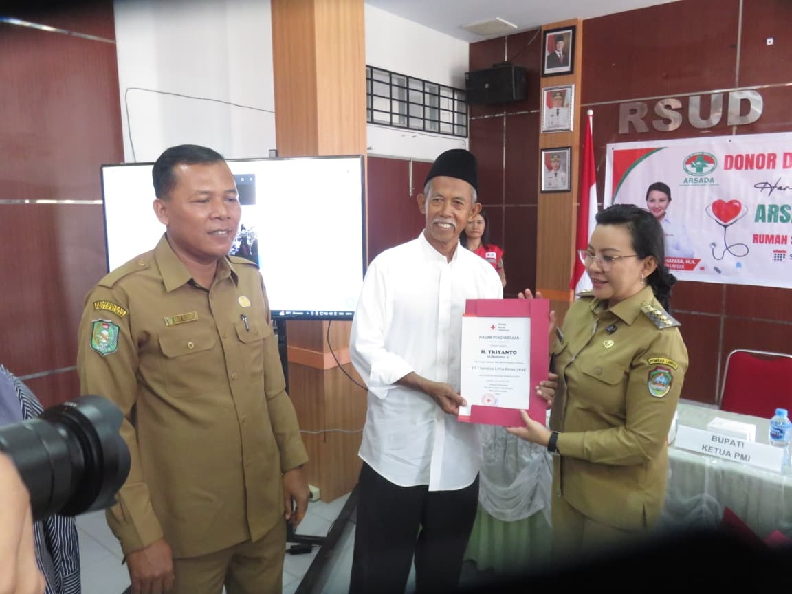 Bupati Landak Karolin Margret Natasa saat menyerahkan sertifikat penghargaan kepada salah satu warga dengan jumlah pendonor darah terbanyak.