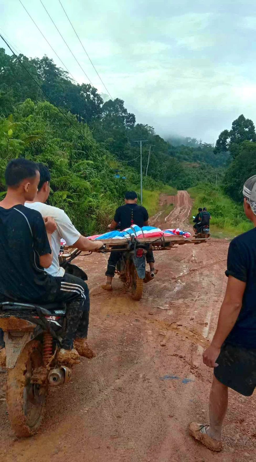 BAWA JENAZAH: Warga Dusun Badat Lama menggotong jenazah dengan ojek akibat jalan rusak parah di Desa Suruh Tembawang, Sanggau.