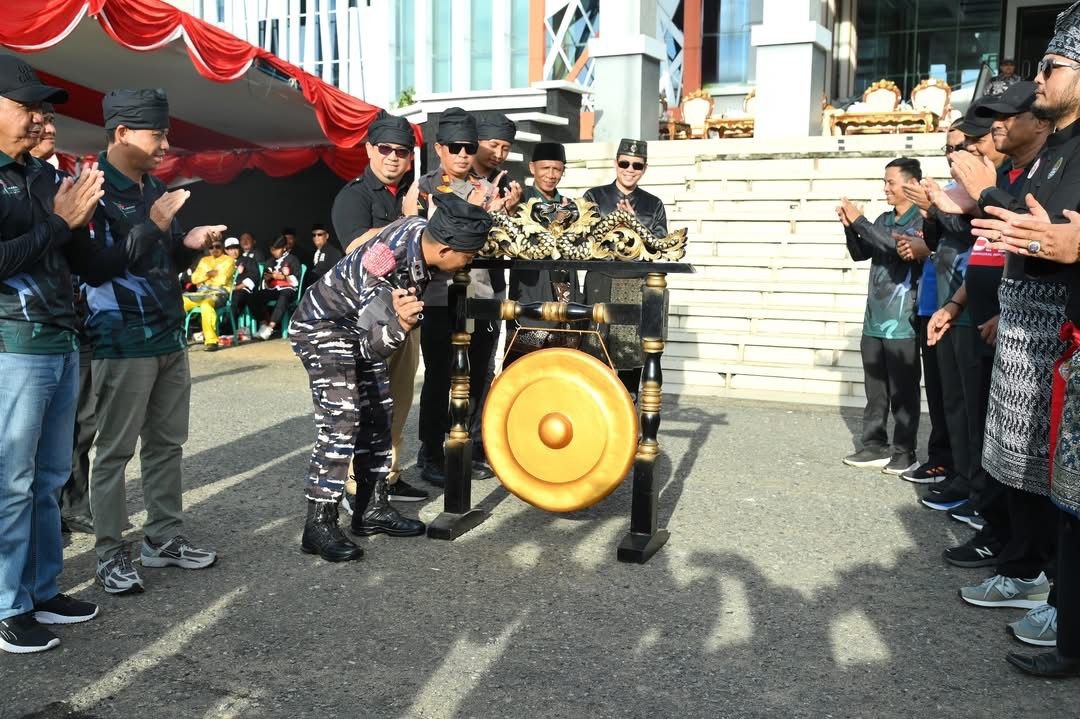 JAMBORE SILAT: Komandan Lanal Ketapang, Letkol Laut (P) Avif Hidayaturohman, memukul gong sebagai tanda dimulainya Jambore Pencak Silat Bupati Cup 2025, Minggu (9/11).