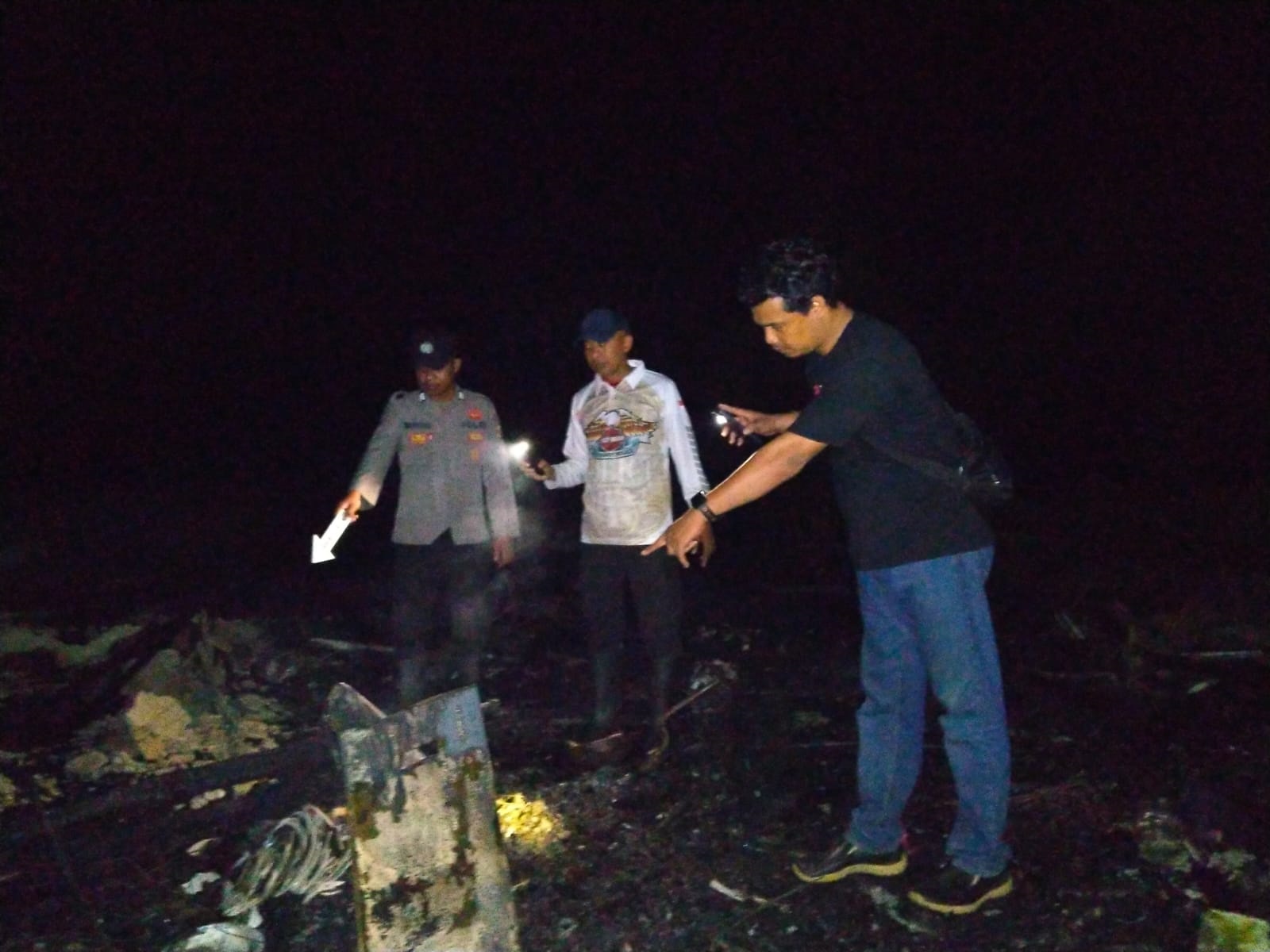 PERIKSA: Petugas kepolisian saat melakukan pemeriksaan atas terjadinya kebakaran mes karyawan PT Laik, perusahaan perkebunan sawit.