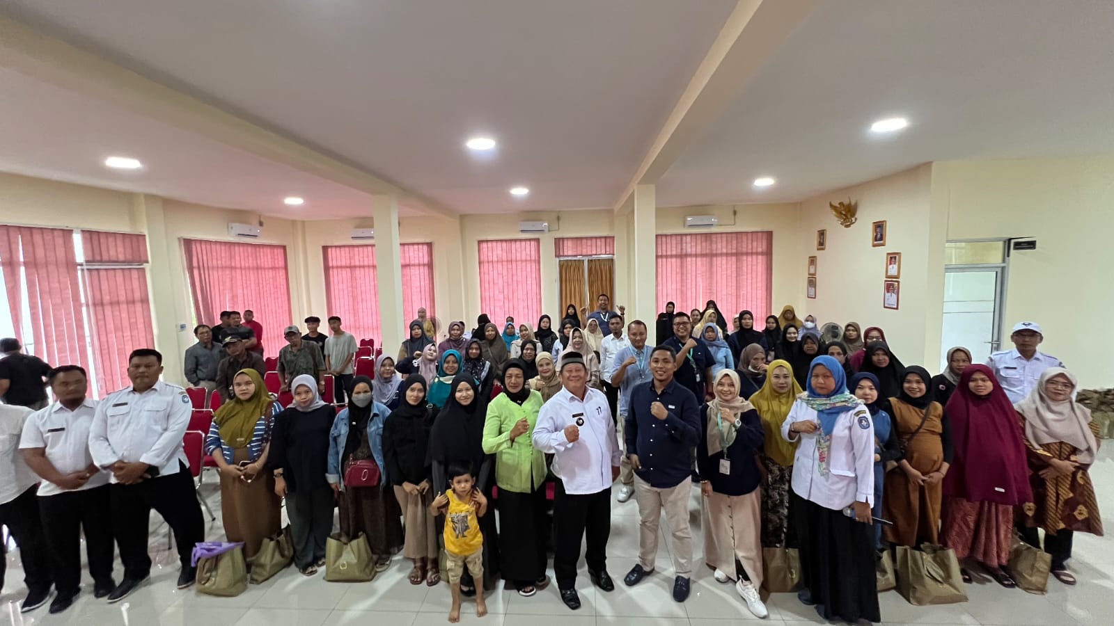 Airport Operation, Services & Security Division Head Bandara Internasional Supadio, Mohammad Arifin, berfoto bersama penerima bantuan fasilitas voli dan paket stunting di Desa Limbung, Sungai Raya.