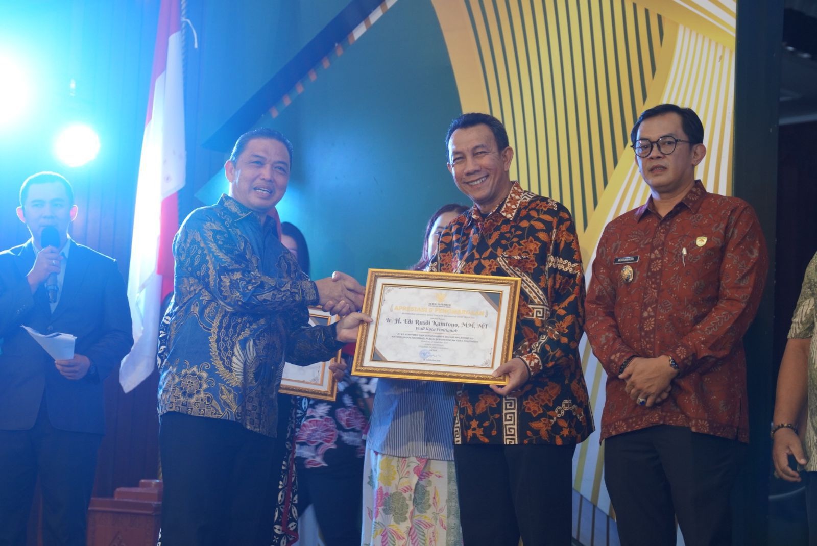 PIAGAM: Kepala Dinas Komunikasi dan Informatika Kota Pontianak Zulkarnain saat menerima piagam penghargaan dari Komisi Informasi Provinsi Kalbar.