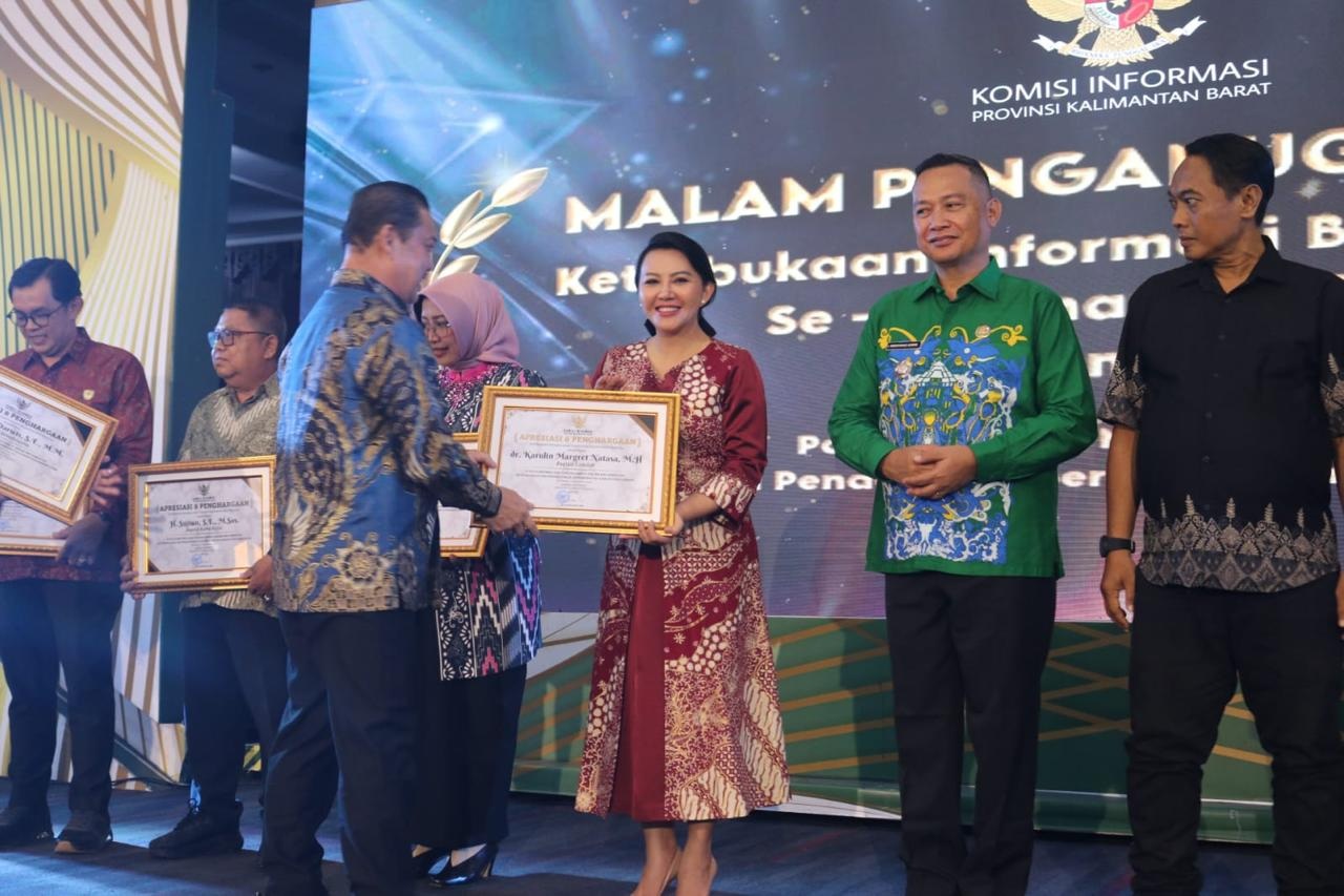 Bupati Landak Karolin Margret Natasa menerima penghargaan keterbukaan informasi dari Komisi Informasi Kalbar yang diserahkan Gubernur Ria Norsan.   / Ist