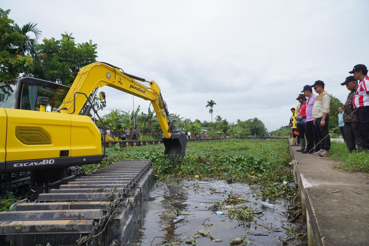 BERSIHKAN PARIT: Alat berat excavator amfibi digunakan untuk membersihkan tumbuhan air dan mengangkat lumpur dari dasar Parit Sungai Jawi Pal Lima. Uji coba penggunaan alat berat excavator amfibi