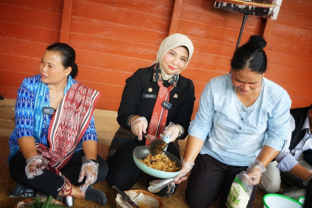 KULINER: Kepala Disporapar Kalbar Windy Prihastari memasak Jimot Lulun bersama warga di Desa Kumpang Ilong, Kabupaten Sekadau.