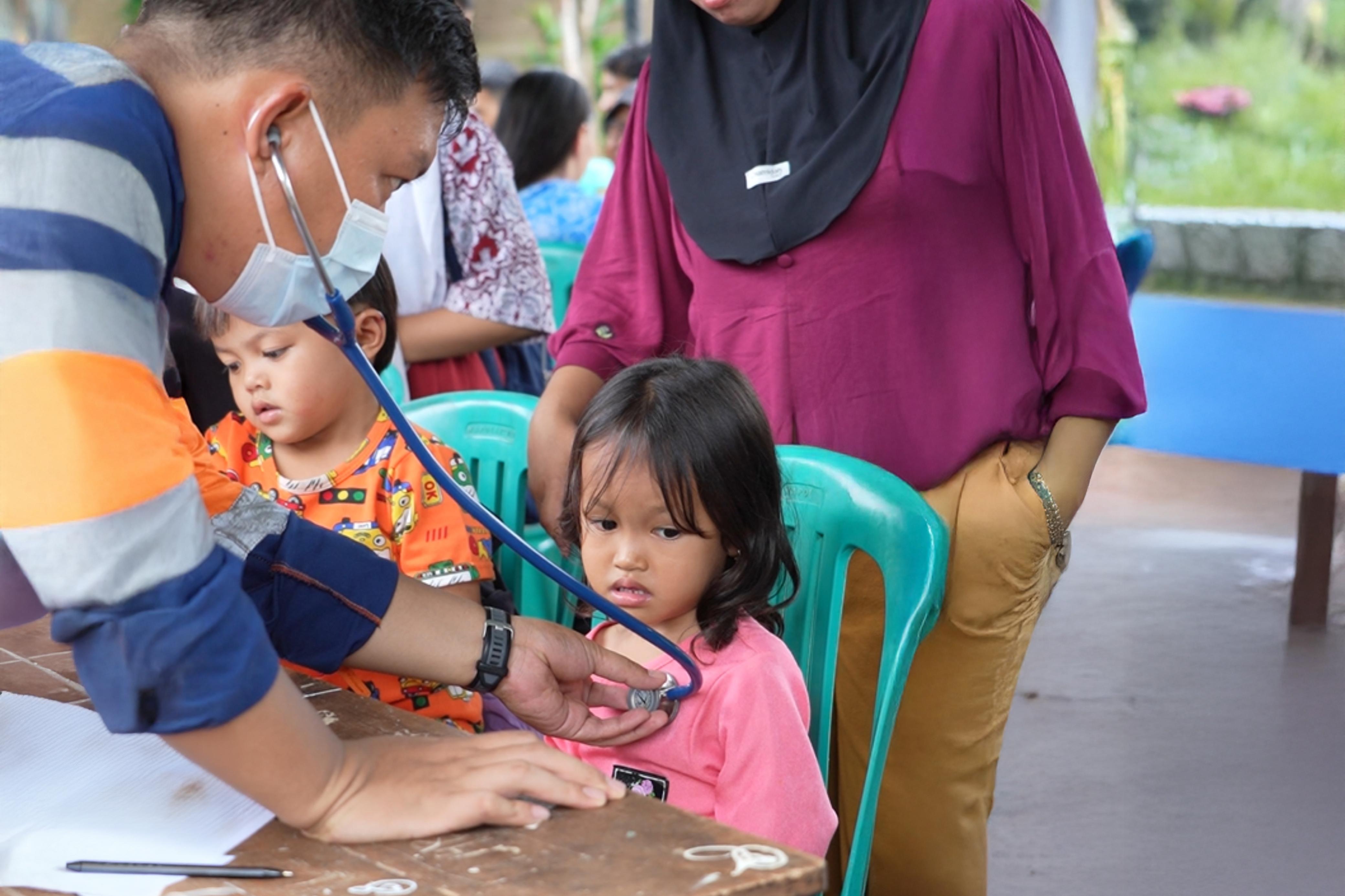 PERIKSA : Tak hanya orangtua, anak-anak juga mengikuti pemeriksaan dan pengobatan gratis yang digelar CMI.