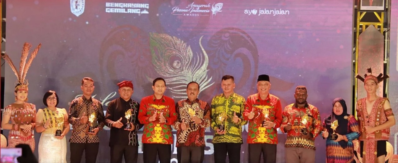 Kepala Dinas Pemuda, Olahraga, dan Pariwisata Kabupaten Sintang, Hendrika, yang mewakili pemerintah daerah (dua dari kiri) mewakili Pemkab Sintang menerikan penghargaan Destinasi Unik di API Awards