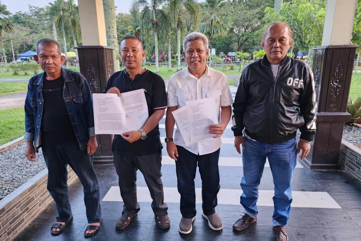Pelapor resmi Iwan Darmawan (baju hitam) didampingi tim dan Muda Mahendrawan (baju putih) didampingi kuasa hukum, menunjukkan surat kesepakatan damai dan surat pencabutan laporan oleh pelapor.