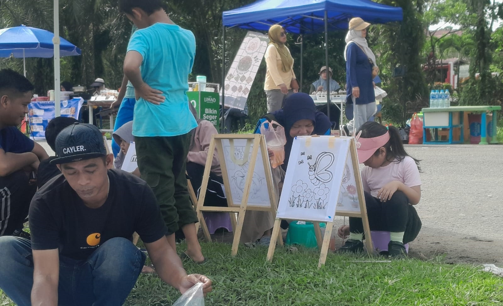 Seorang anak ditemani orang tuanya saat mengikuti kegiatan melukis atau mewarnai di lokasi CFD Sambas.
