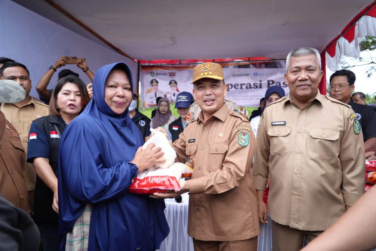 Gubernur Kalimantan Barat Ria Norsan menyerakan paket bahan pokok yang dibeli masyarakat saat peluncuran program Gema Membangun Desa di Kantor Camat Sungai Kakap.