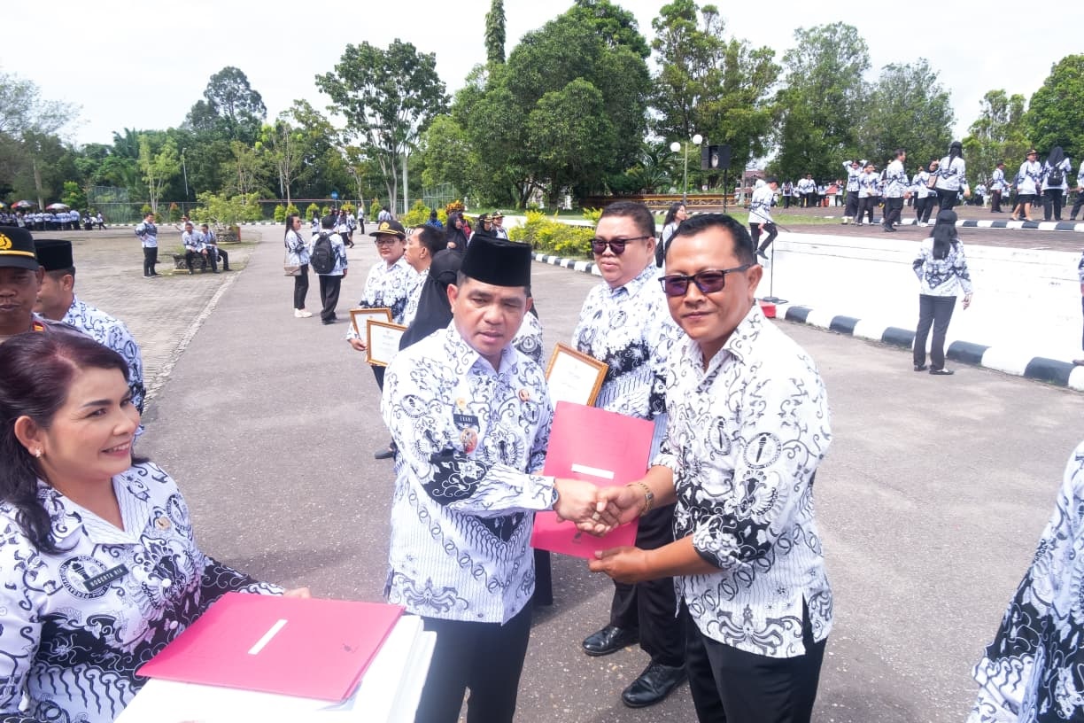 Wakil Bupati Landak Erani saat menyerahkan plakat penghargaan kepada sejumlah guru dalam petingatan HUT PGRI dan hari guru Nasional di halaman kantor Bupati Landak.