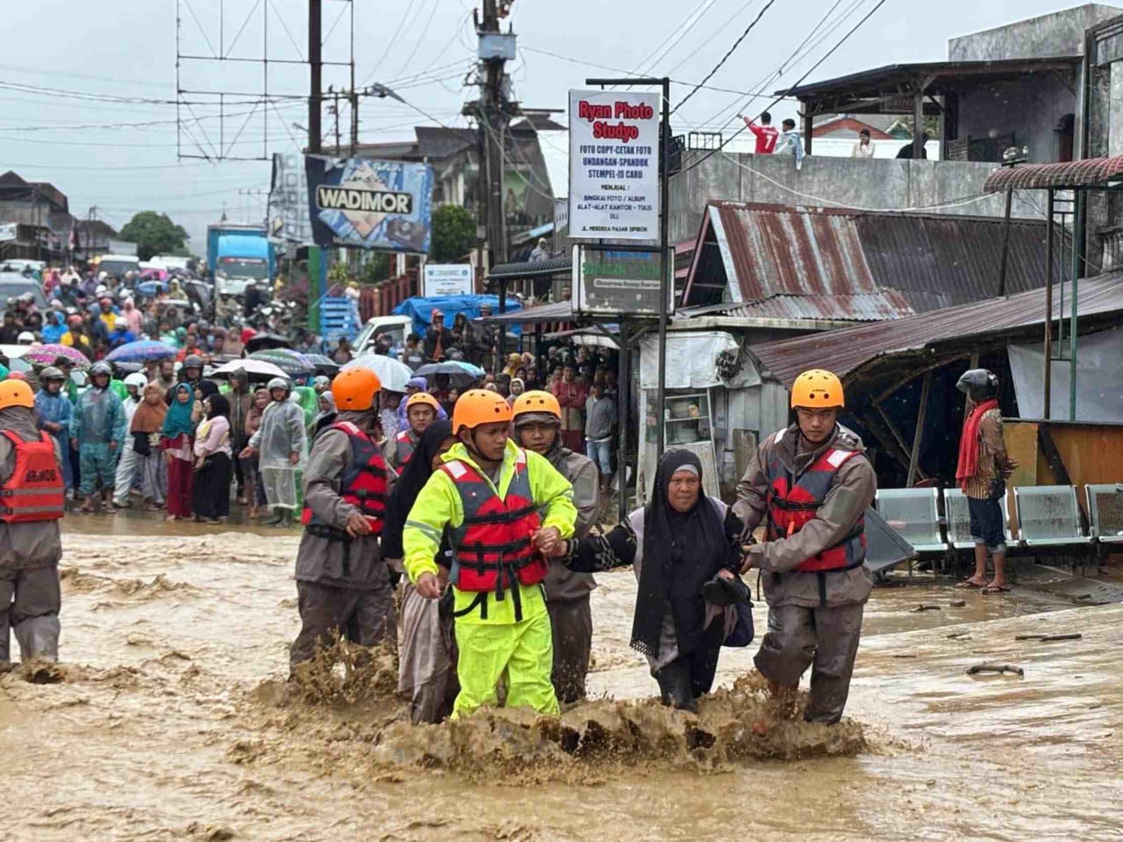 EVAKUASI: Petugas mengevakuasi warga yang terkena dampak banjir di Tapanuli Utara, Sumatera Utara, kemarin.