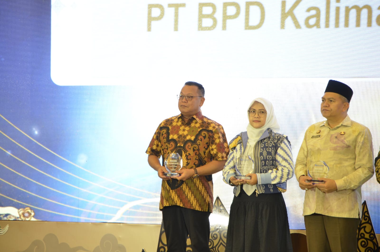 PENGHARGAAN : Dirut Bank Kalbar, Rokidi (kiri) berdiri menerima penghargaan bagi Bank Kalbar dalam ajang Bank Indonesia Award 2025 yang digelar saat PTBI, Jumat (28/11).
