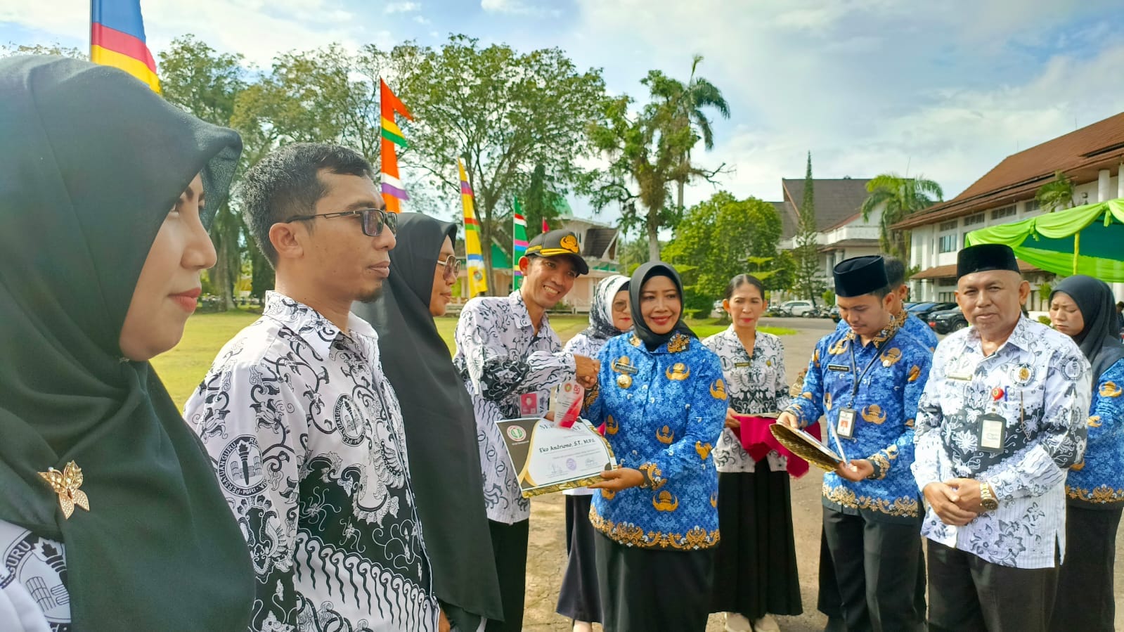 PENGHARGAAN: Bupati Erlina menyerahkan penghargaan pada momentum peringatan HUT PGRI dan Korpri di Halaman Kantor Bupati Mempawah