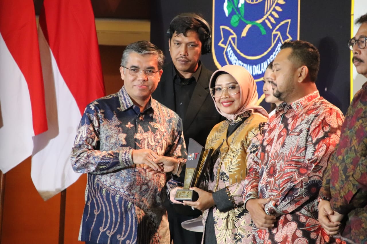 Bupati Erlina saat menerima penghargaan dari Menteri Tenaga Kerja.