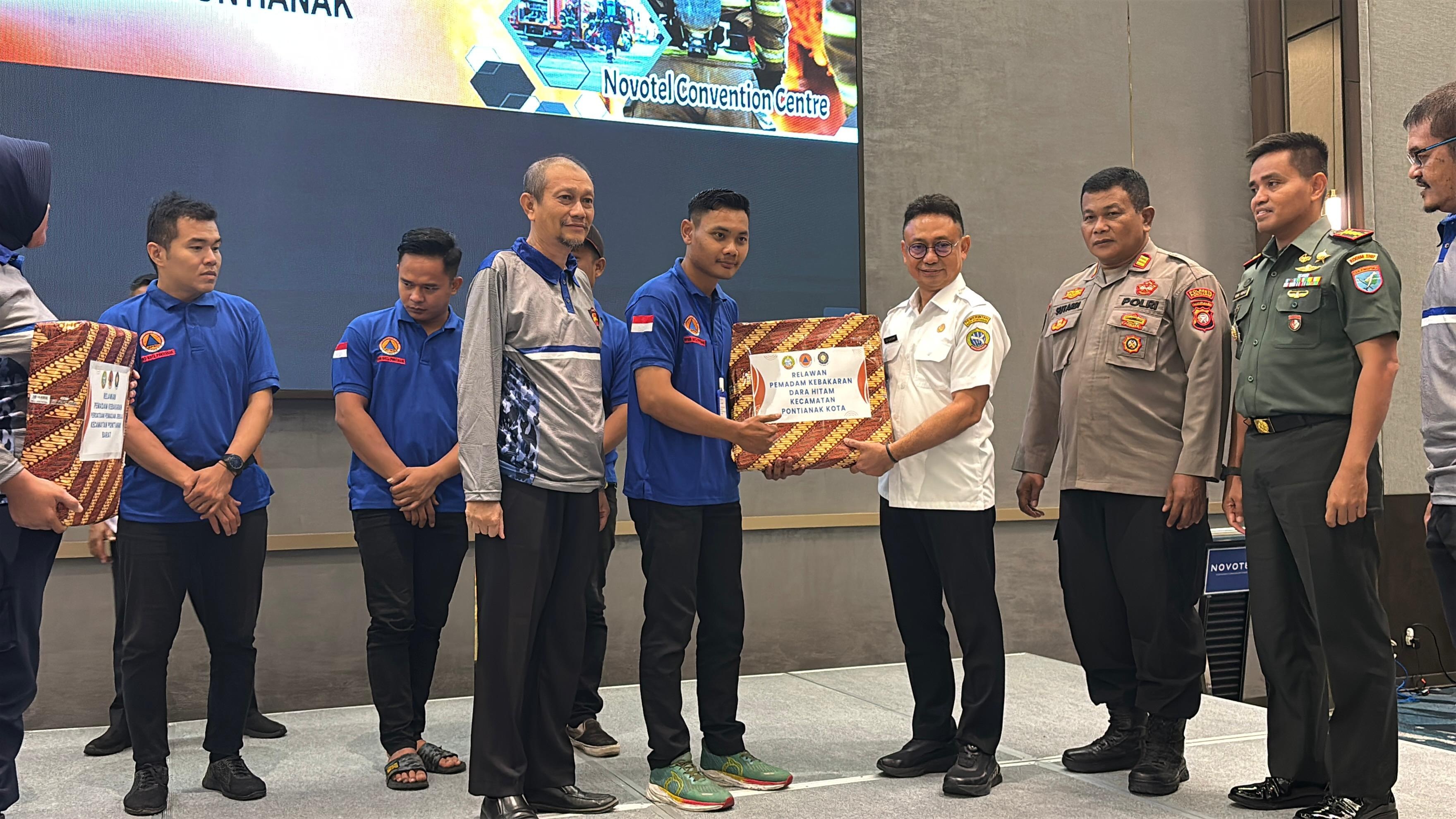 BANTUAN: Wali Kota Pontianak Edi Rusdi Kamtono menyerahkan secara simbolis bantuan selang pemadam kebakaran kepada anggota relawan damkar.