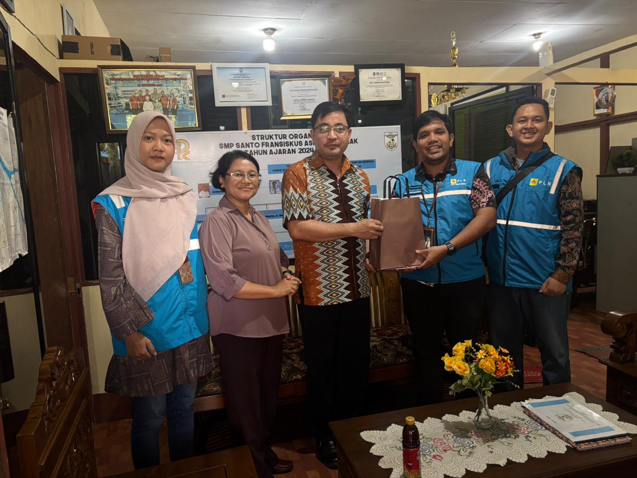 Manager ULP Siantan, Julian Maruli (kedua dari kanan) dan Tim PLN menyerahkan cindera mata dan berfoto bersama Kepala Sekolah SMP Yayasan Pancur Kasih, Agustinus (tengah),