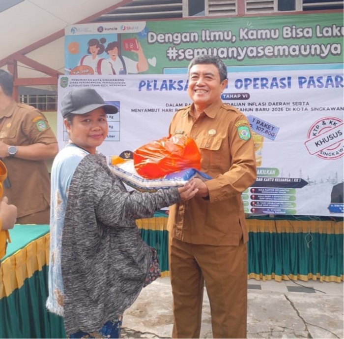 SERAHKAN: Kepala Disdaginkop UKM Kota Singkawang, Yasmalizar menyerahkan paket sembako bersubsidi pada Operasi Pasar Tahap VI di Singkawang kepada warga.