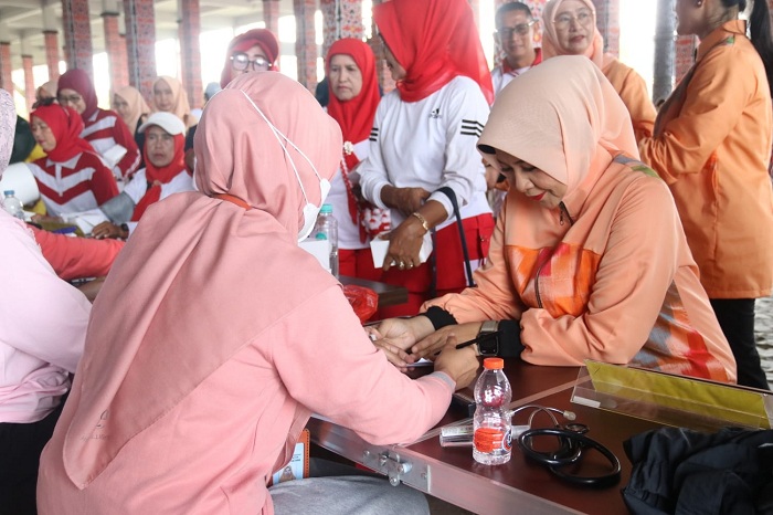 CEK KESEHATAN: Ketua DWP Kalbar Windy Prihastari sedang memeriksa kesehatan saat kegiatan senam bersama untuk peringatan HUT ke-26 DWP.