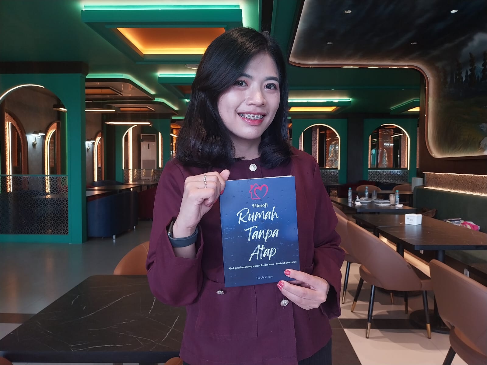 BUKU : Caroline Tjen berfoto menunjukkan buku berjudul Filosofi Rumah Tanpa Atap, karya kedua yang ia tulis.