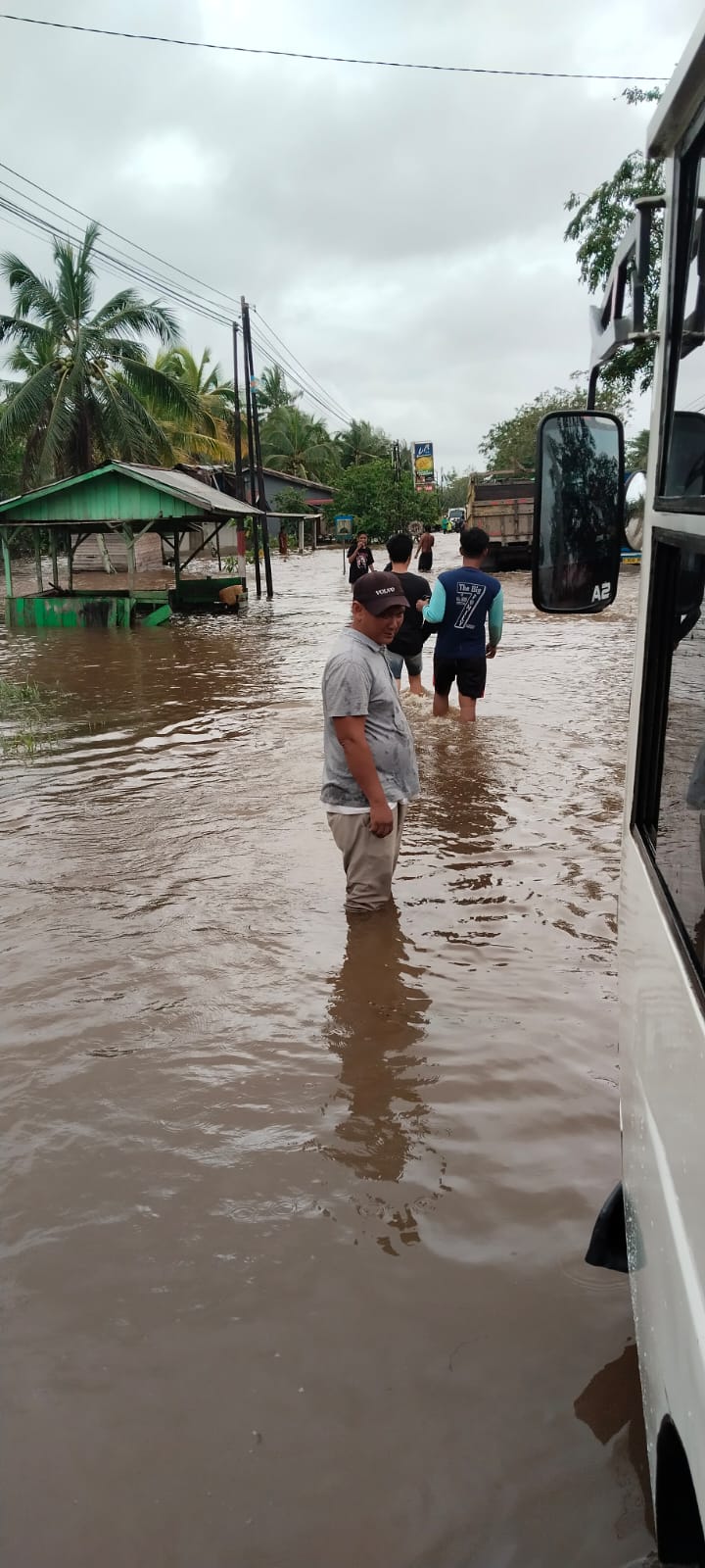 Warga membantu mengarahkan kendaraan roda dua dan roda empat yang terjebak banjir di sepanjang Jalan Peniti.