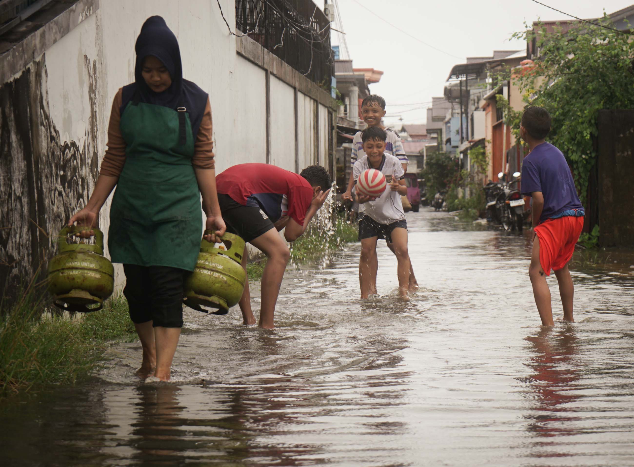 AIR PASANG: Warga melintasi genangan air di gang Berkah Jalan Veteran. Sejumlah kawasan rendah di Kota Pontianak terandam air akibat pasang air laut.