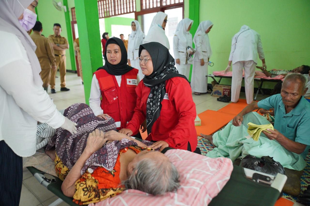DIUNGSIKAN: Warga lansia yang diungsikan di Aula Kantor Camat Pontianak Barat tengah mendapat perawatan medis.