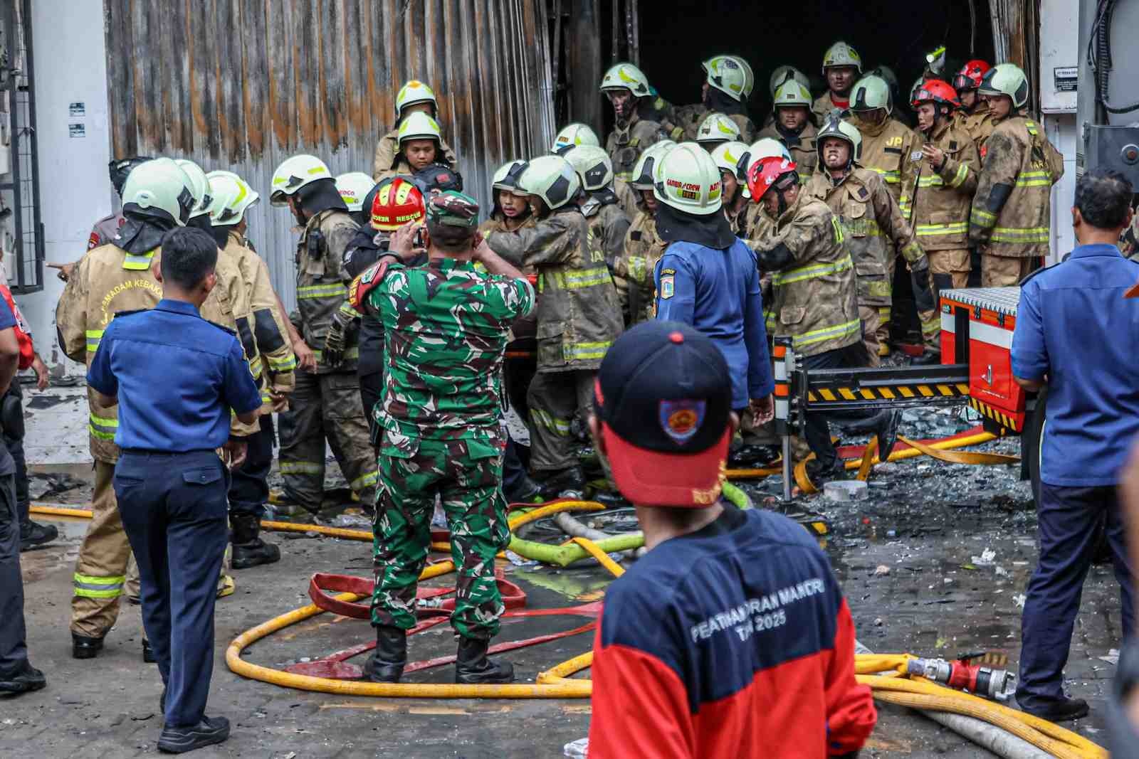 EVAKUASI KORBAN: Sejumlah petugas gabungan mengevakuasi korban kebakaran di sebuah toko elektronik di Kawasan Cempaka Putih, Jakarta, Selasa (9/12). Berdasarkan data terakhir ditemukan korban meningga