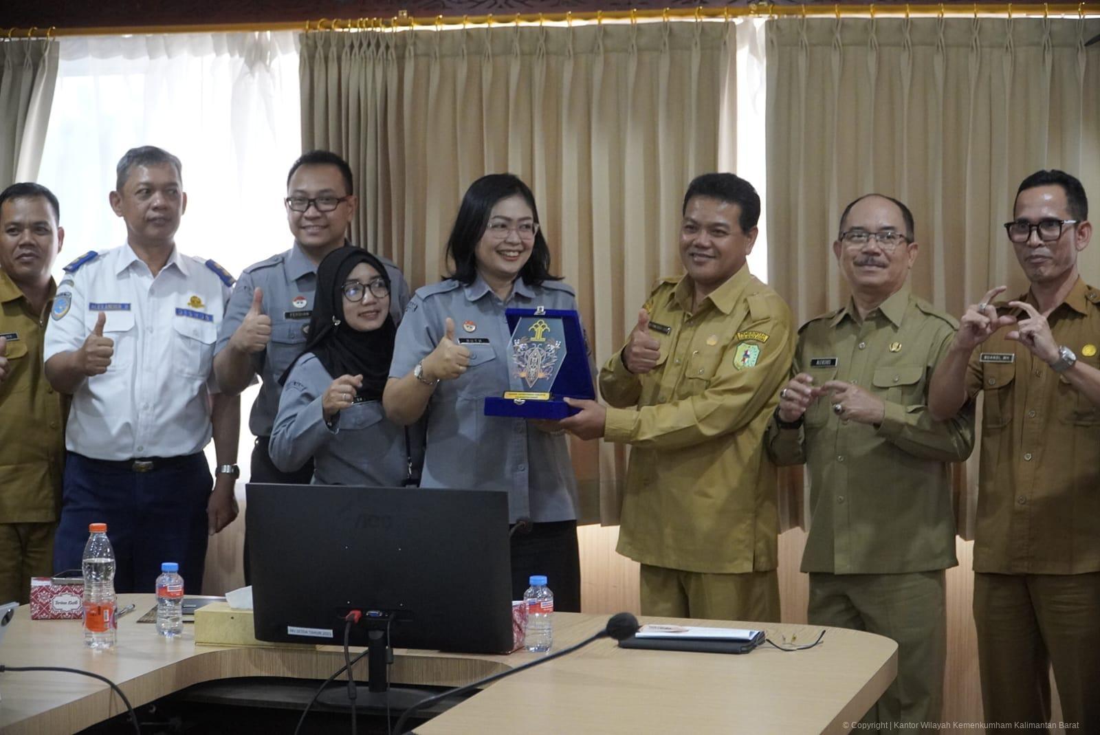 Penyerahan cendera mata dalam kegiatan sosialisasi peraturan oleh Kantor Wilayah Kemenkum Kalbar di Kabupaten Bengkayang.