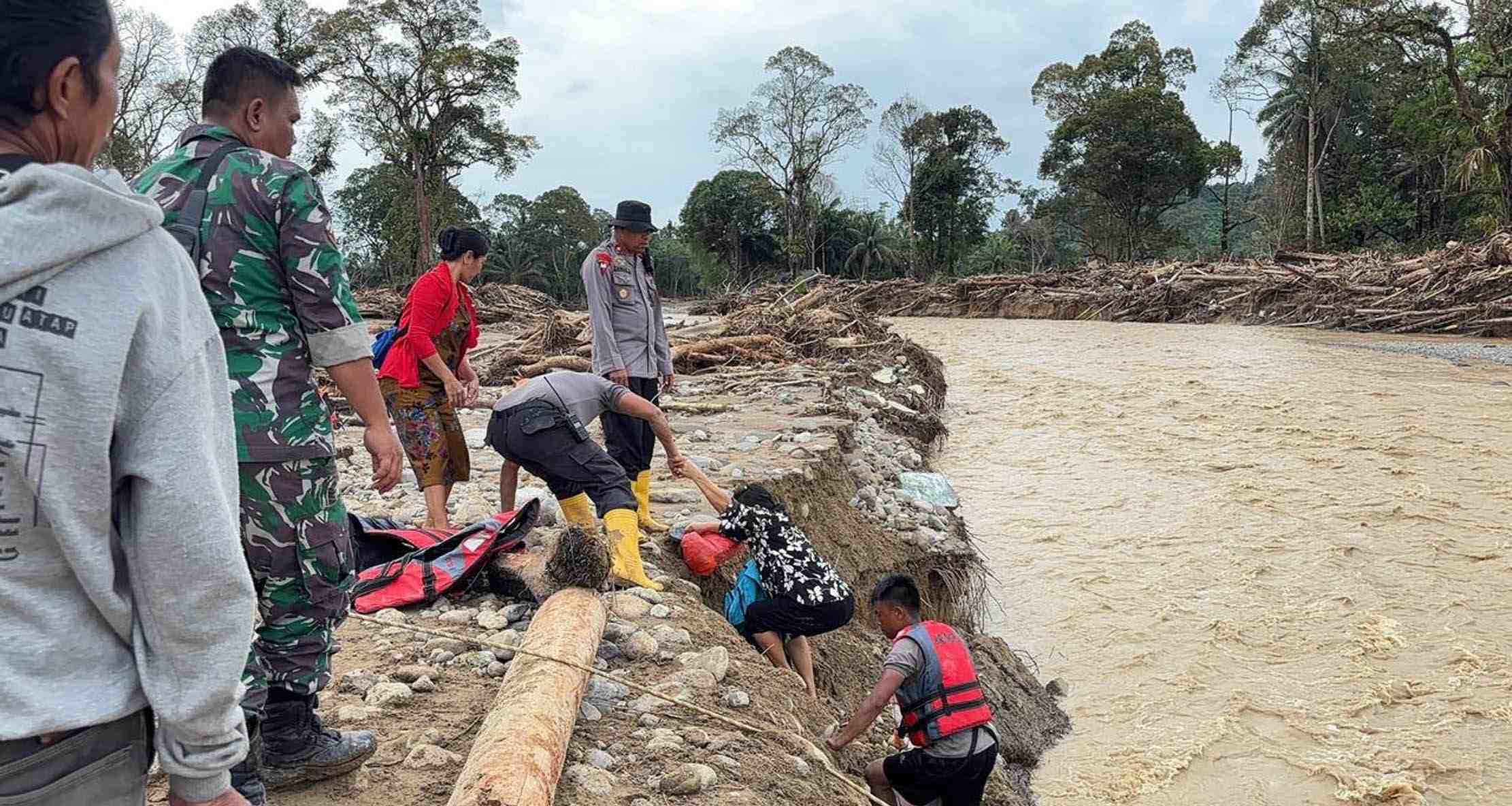 BANTU KORBAN BANJIR: Tim Polri Membantu menyeberangkan korban banjir bandang di Batang Toru, Kabupaten Tapanulis Selatan pada Rabu (10/12).