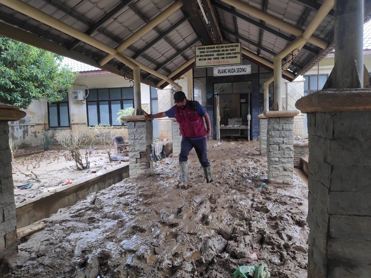 BERSIHKAN LUMPUR: Petugas rumah sakit membersihkan lorong RSUD Aceh Tamiang, Senin (15/12).