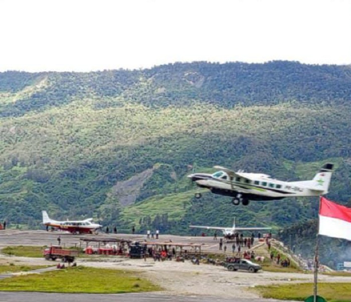 Pesawat lepas landas dari Bandara Tigiles Sinak, Puncak, Papua Tengah, memperlihatkan keindahan alam sekitar dan aktivitas penerbangan yang sibuk.