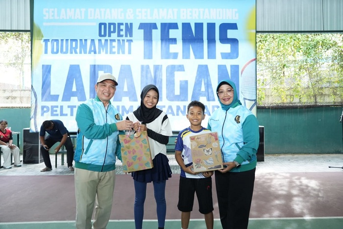 BINGKISAN: Gubernur Kalbar Ria Norsan didampingi istri Erlina, saat menyerahkan bingkisan kepada anak-anak di Open Turnamen Tenis Lapangan PELTI se-Kalimantan Barat Tahun 2025.