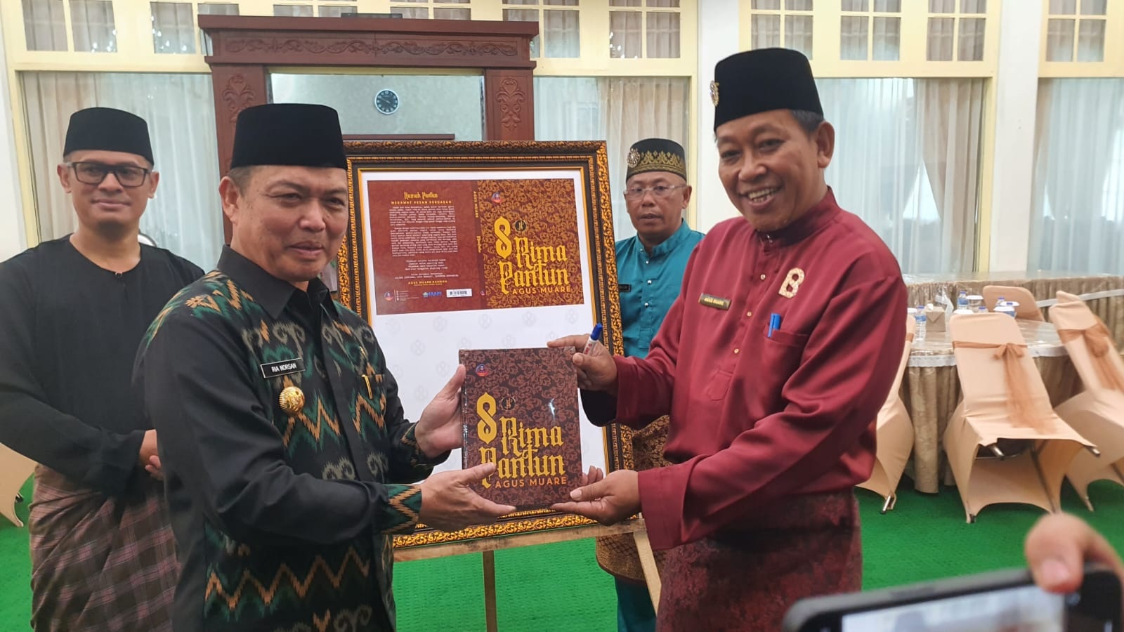SERAHKAN BUKU: Penyerahan buku 8 Rima Pantun dari penulisnya Agus Muare kepada Gubernur Kalbar Ria Norsan.