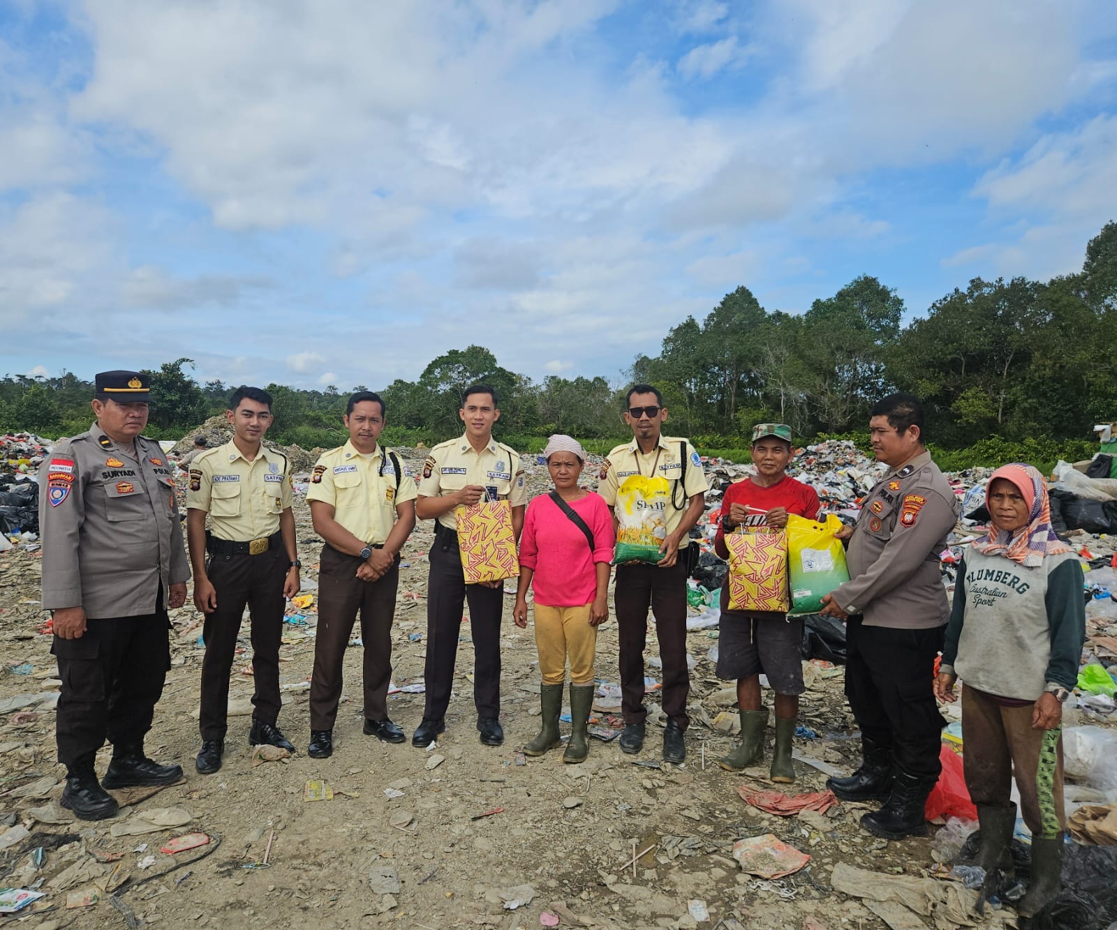 BANTUAN: Personel Satbinmas Polres Kapuas Hulu bersama anggota Satpam membagikan bantuan kepada pekerja TPA Desa Sibau Hilir dalam kegiatan Jumat Berkah, Jumat (19/12).