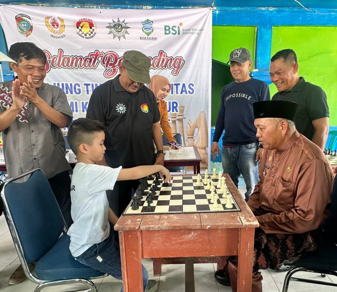 LAWAN PECATUR CILIK: Wabup Juli Suryadi saat menjajal skil bermain catur salah seorang pecatur cilik.