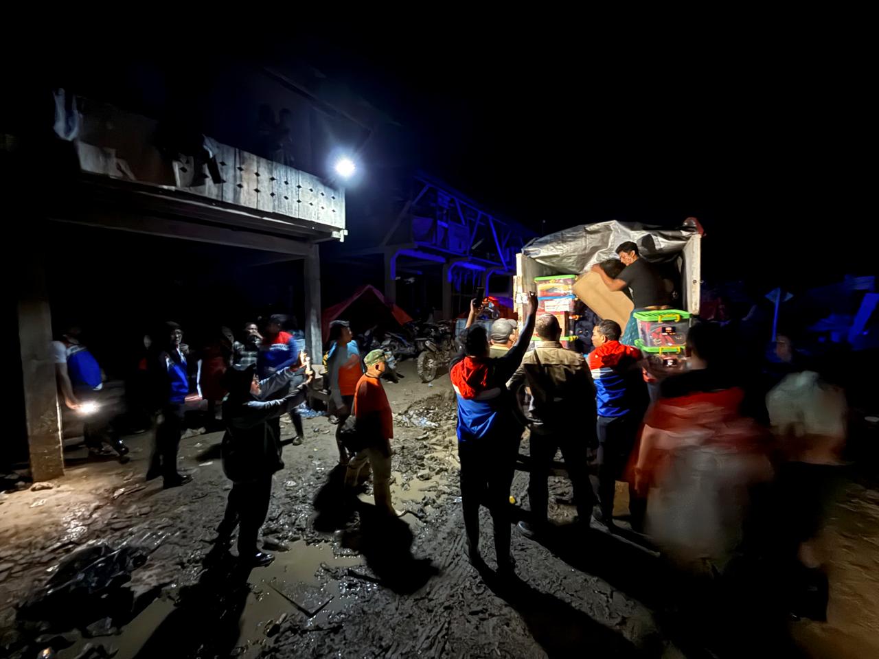 Relawan KPI menurunkan bantuan logistik dari truk untuk warga terdampak banjir di Aceh Tamiang.