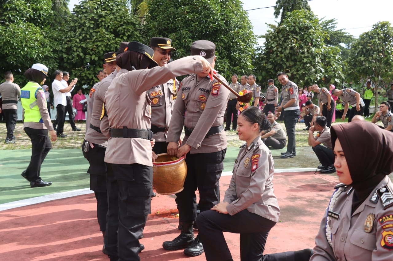 NAIK PANGKAT: Prosesi tradisi penyiraman air bunga saat upacara kenaikan pangkat personel Polres Landak pada Jumat (2/1).