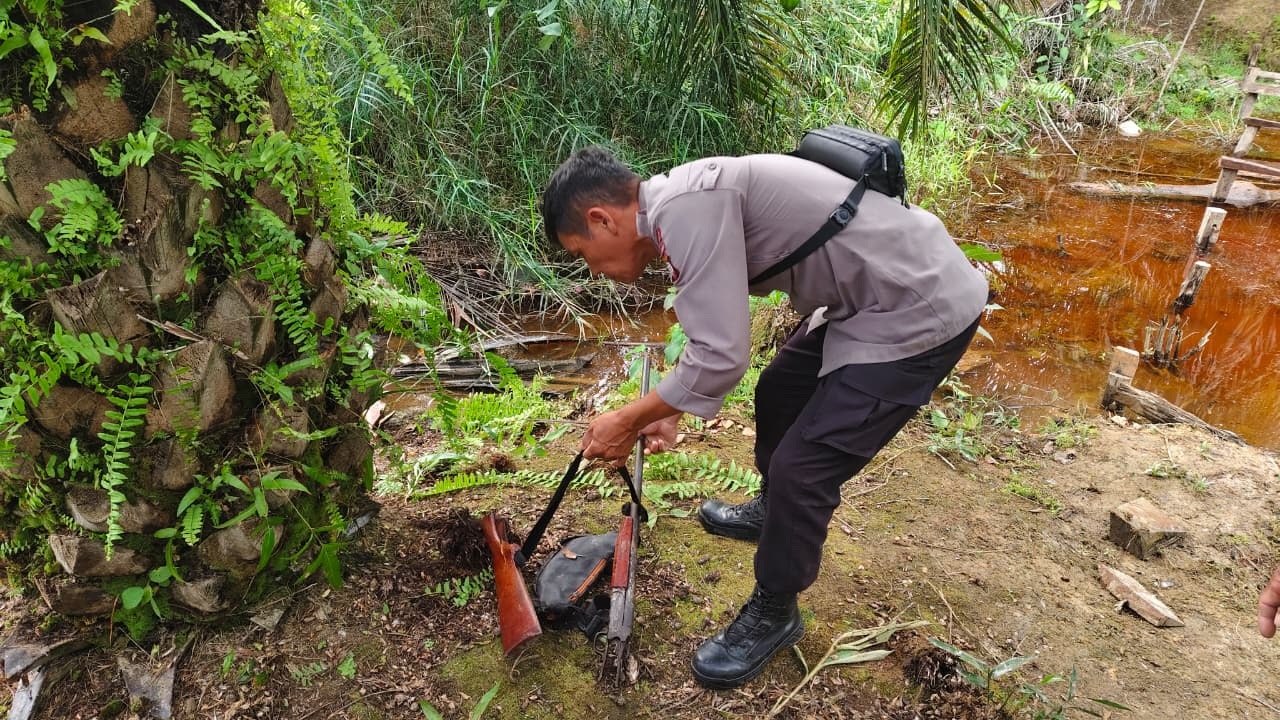 BARANG BUKTI: Anggota Polsek Batang Lupar saat menemukan senjata api laras panjang di lokasi terjadinya kasus penembakan.
