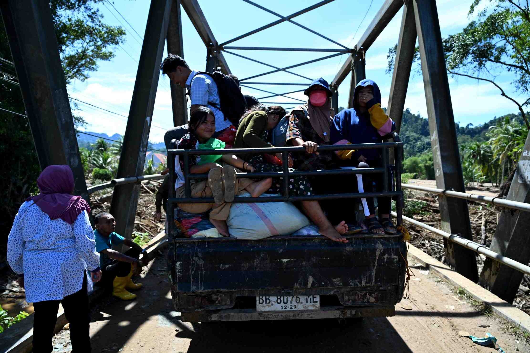 PENGUNGSI: Mobil pikap membawa para pengungsi melintasi jalan di Desa Tukka, Kecamatan Tukka, Kabupaten Tapanuli Tengah, Sumatera Utara pasca-banjir bandang pertengahan Desember lalu.