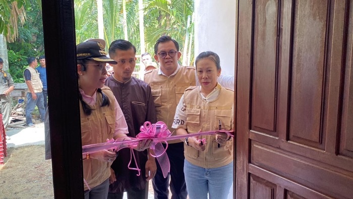 GUNTING PITA: Prosesi pengguntingan pita saat penyerahan secara simbolis dua unit rumah layak huni bantuan dari donatur kepada warga.