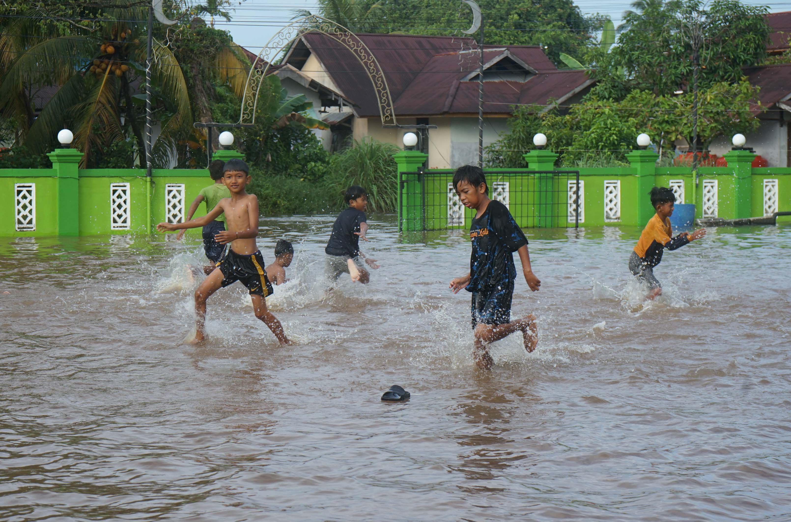 TETAP WASPADA: Anak-anak bermain air saat terjadi pasang air laut di kawasan Jalan Tanjung Harapan Pontianak Timur, Minggu (4/1).