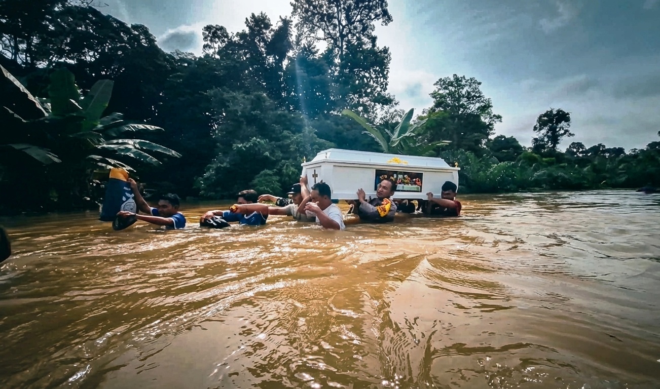 GOTONG JENAZAH: Warga dan polisi memanggul peti jenazah menembus banjir setinggi dada orang dewasa di Kecamatan Beduai, Kabupaten Sanggau, Minggu (11/1), akibat akses jalan terputus dan kendaraan tak