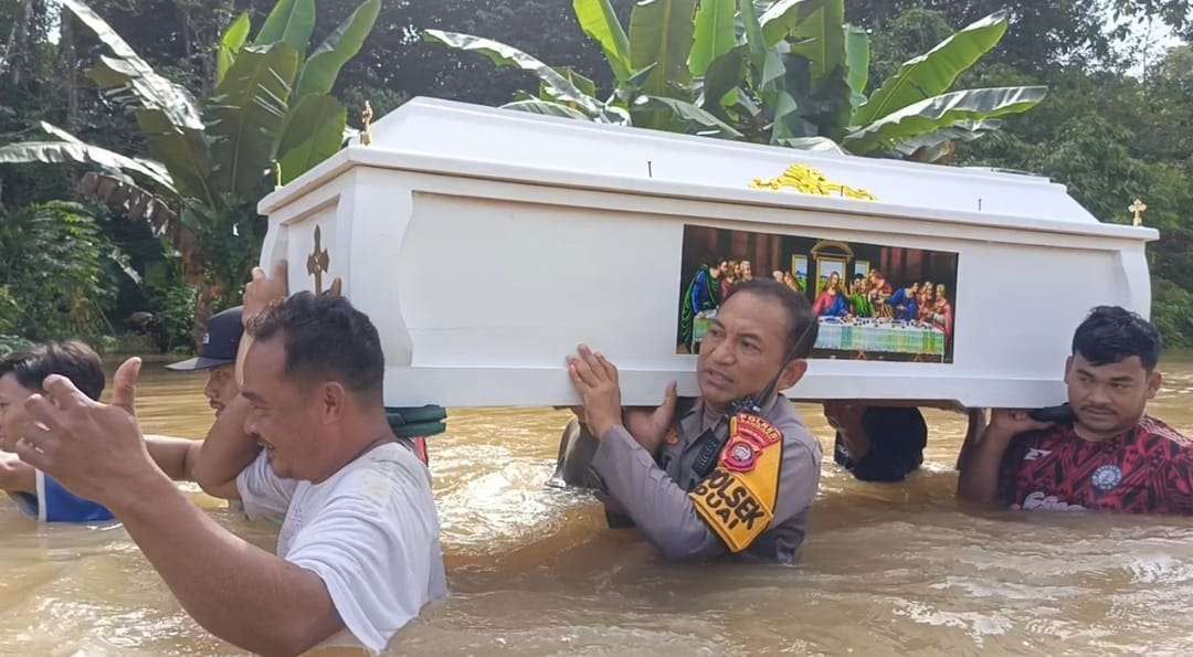 Warga  dan polisi memanggul peti jenazah menembus banjir setinggi dada orang dewasa di Kecamatan Beduai, Kabupaten Sanggau, Minggu (11/1), akibat akses jalan terputus dan kendaraan tak bisa melintas.