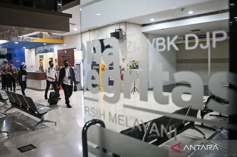 GELEDAH: Petugas KPK membawa barang bukti usai melakukan penggeledahan di Kantor Pelayanan Pajak Madya Jakarta Utara, Jakarta, Senin (12/1/2026).